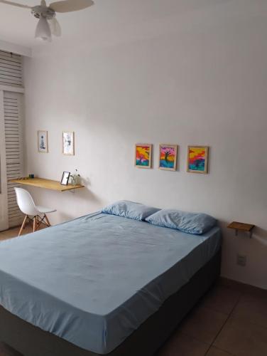 a bedroom with a bed and a desk with a fan at Projeto FZ Hospedagem in Salvador