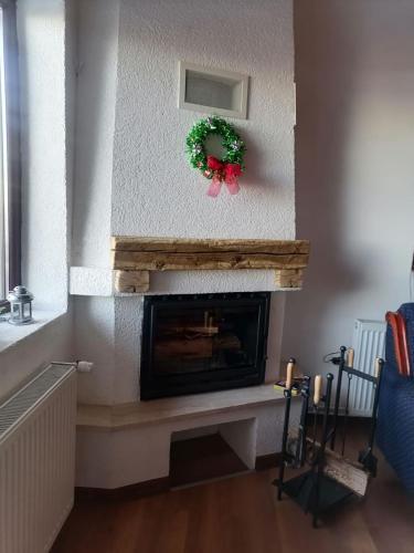 a living room with a fireplace with a christmas wreath at Apartments Holiday Home Srce in Kopaonik