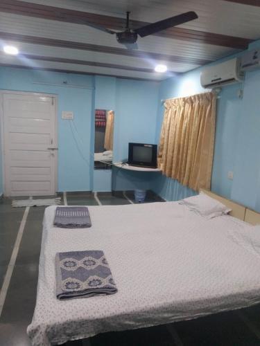 a room with a bed and a tv in it at Gayatri Holiday Home in Murud