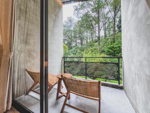 a balcony with two chairs and a table at Arunika Villa in Ciloto