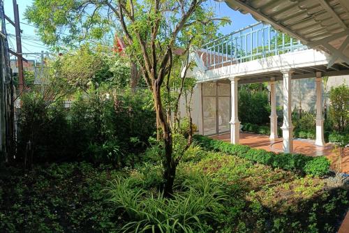 a garden with a tree and a walkway at Baan Debtida in Bangkok