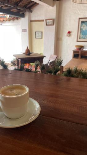 a cup of coffee sitting on top of a wooden table at Hotel Casa Valentino in Tibasosa