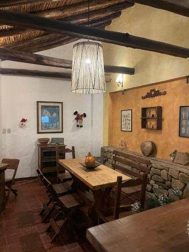 a dining room with a wooden table and a chandelier at Hotel Casa Valentino in Tibasosa