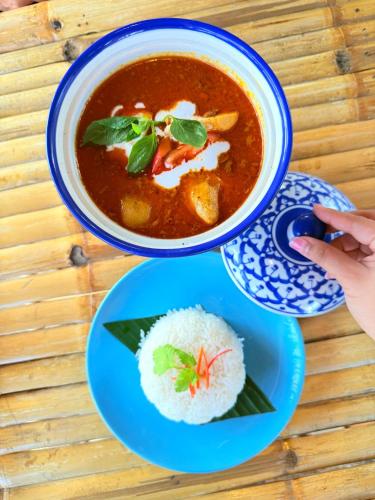 a bowl of soup and a plate of rice at Three Trees Samui Resort - Sarocha Villa in Lamai