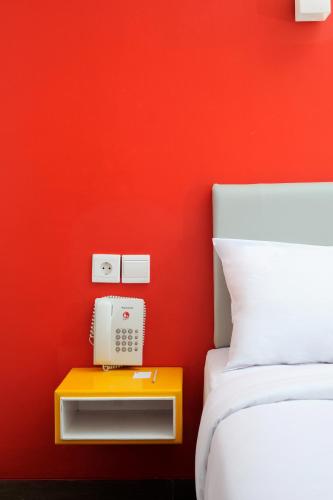 a red bedroom with a bed and a phone on a table at Amaris Hotel Setiabudhi - Bandung in Bandung