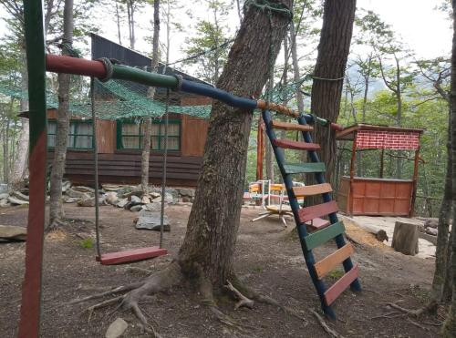 a playground in front of a log cabin at El Isleño in Ushuaia