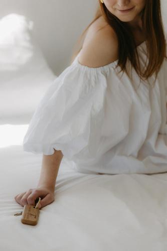 a woman in a white dress laying on a bed with a key at Mas de la Fouque - Hôtel & Spa in Saintes-Maries-de-la-Mer