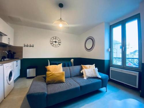 un salon avec un canapé bleu avec des oreillers dans l'établissement Joli Duplex - centre ville - Verde, à Angers