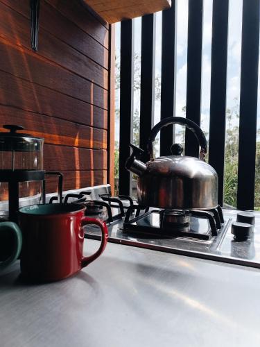 a tea kettle sitting on top of a stove at Cabaña Momotus II in Concepción