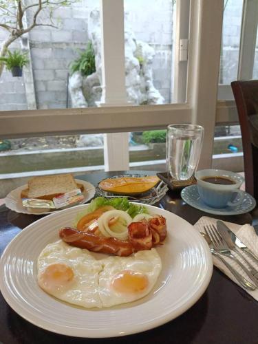 a plate of food with eggs and bacon on a table at Baan Debtida in Bangkok