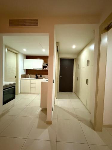 an empty kitchen with white cabinets and a door at Suite 419 TQ Plaza in Budva