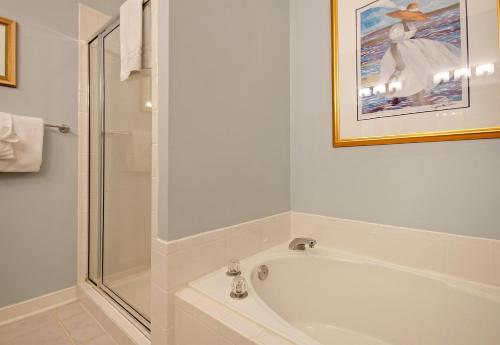 a bathroom with a tub and a glass shower at OG02: 2 Ocean Green in Kiawah Island