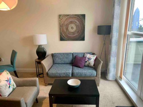 a living room with a couch and a table at Modern 2 Bedroom Apartment with Sea view in Felixstowe