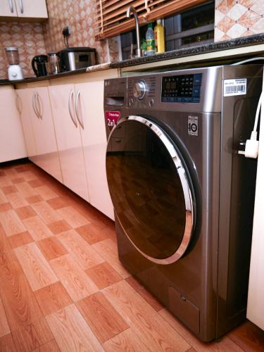 a stainless steel washing machine in a kitchen at Sleeps8-Parking-Jacuzzi-WiFi-AirCon in Iseri-Oke