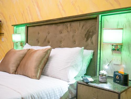 a bed with a wooden headboard and a table with a lamp at Sleeps8-Parking-Jacuzzi-WiFi-AirCon in Iseri-Oke