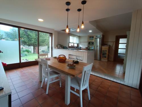 una cucina e una sala da pranzo con tavolo e sedie in legno di As Pagonas a Moaña