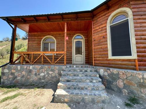 a log cabin with stairs leading to the front door at Shahdag wood house in Qusar