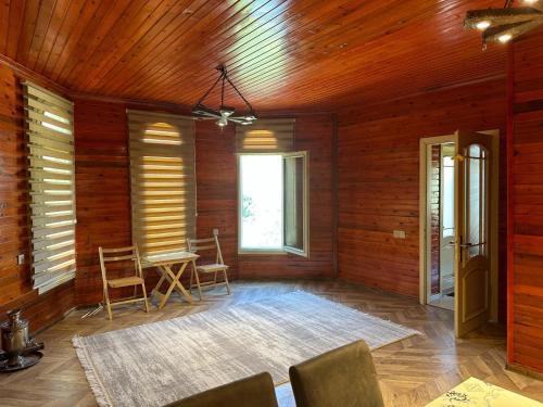 a room with wooden walls and a table and chairs at Shahdag wood house in Qusar