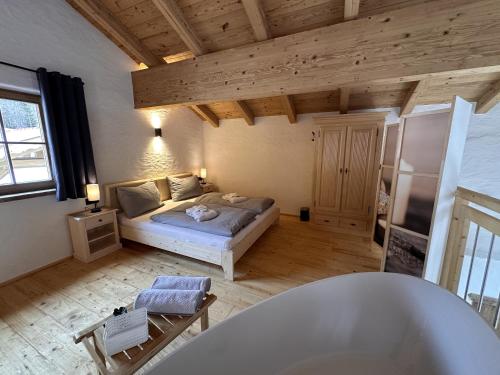 a bedroom with a bed and a tub in a room at Chalet am Bachl 1 in Flattach