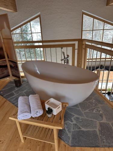 a bath tub sitting in a room with two towels at Chalet am Bachl 1 in Flattach
