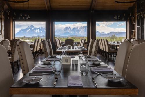 a long table in a restaurant with mountains in the background at Río Serrano Hotel + Spa in Torres del Paine