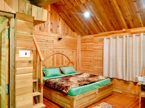 a bedroom with a bed in a wooden cabin at woodland duplex cottage 2 Jibhi in Jibhi