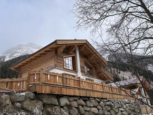 a log cabin on top of a stone wall at Chalet am Bachl 1 in Flattach