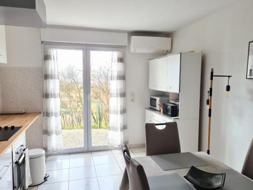 Il comprend une cuisine équipée d'une table et d'un réfrigérateur. dans l'établissement Gîte de 70m² avec vue sur le massif du Pilat, à Clonas-sur-Varèze