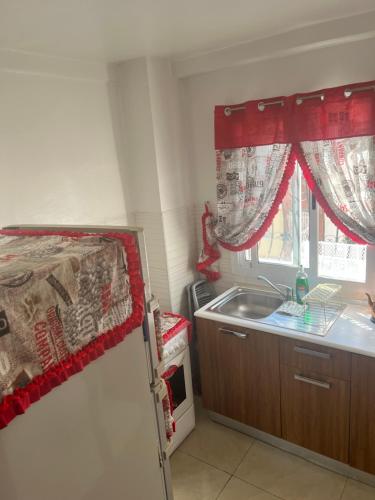 a small kitchen with a sink and a refrigerator at Residence arraha in Tangier