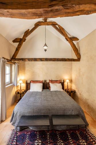 une chambre avec un grand lit dans une pièce dans l'établissement Le Domaine des Ormeaux, à Saint-Alvère