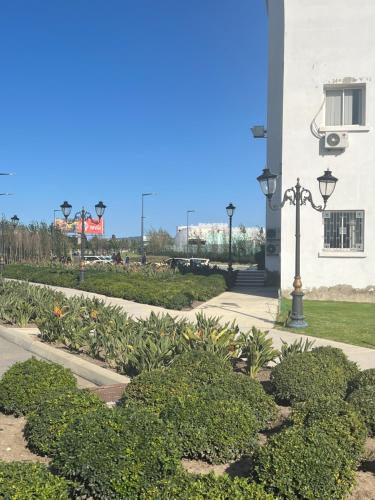 a street light next to a building with bushes at Residence arraha in Tangier