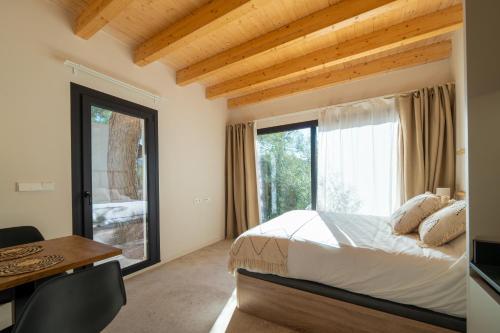 a bedroom with a bed and a desk and a window at Alojamiento Rural 1Respiro Parque Natural Serra Calderona in Serra