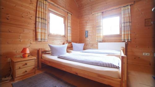 2 Betten in einem Blockhaus mit 2 Fenstern in der Unterkunft Almdorf Präbichl in Vordernberg