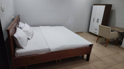 a bedroom with a bed and a desk and a chair at Jakara Avenue Hotel- Tamale in Kyanshiogo