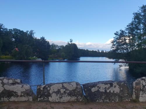 a view of a lake with rocks in the foreground at House in nature in Broby