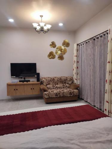 a living room with a couch and a flat screen tv at Cosy Vista in Canacona