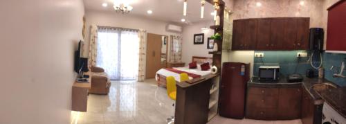 a living room with a bed and a kitchen at Cosy Vista in Canacona