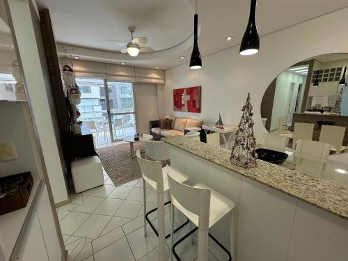 a kitchen and living room with a counter and chairs at Ap Completo /Ar e Wi-Fi/ Riviera in Riviera de São Lourenço