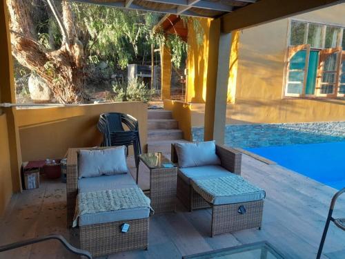 a patio with chairs and a table and a pool at Casa los Misticos, Vicuña, Valle del Elqui in Vicuña