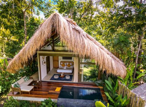 a resort room with a pool and a thatch roof at Private Villa with Pool - Kalani River Villas in General Luna