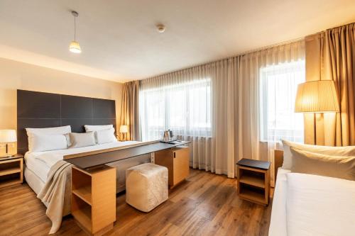 a hotel room with a bed and a desk at Biancaneve Family Hotel in Selva di Val Gardena