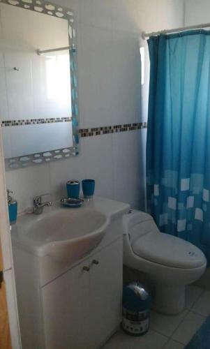 a bathroom with a sink and a toilet and a mirror at Spa, piscina y cabañas Tierra Mar in La Montaña