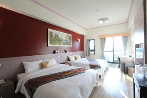 a hotel room with two beds and a couch at Emilia Resort I in Hengchun