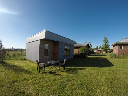 a small house with a table and chairs in a yard at Spa, piscina y cabañas Tierra Mar in La Montaña