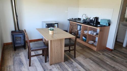 a kitchen with a wooden table and a stove at Spa, piscina y cabañas Tierra Mar in La Montaña