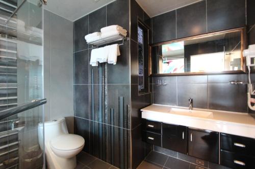 a bathroom with a toilet and a sink and a mirror at Emilia Resort I in Hengchun