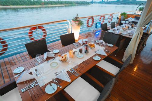 a dining table on a boat on the water at Acamar Nile Cruise - Every Monday from Luxor for 04 & 07 Nights - Every Friday From Aswan for 03 & 07 Nights in Luxor