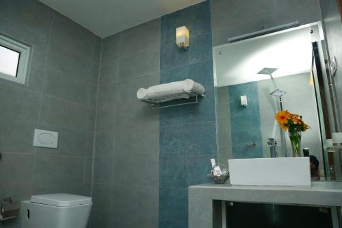 W łazience znajduje się umywalka, lustro i toaleta. w obiekcie The Forest Chalet w mieście Tissamaharama