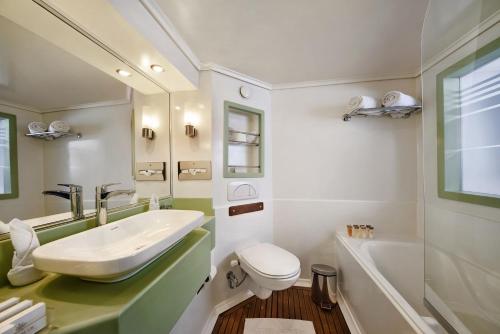 a bathroom with a sink and a toilet and a tub at Acamar Nile Cruise - Every Monday from Luxor for 04 & 07 Nights - Every Friday From Aswan for 03 & 07 Nights in Luxor