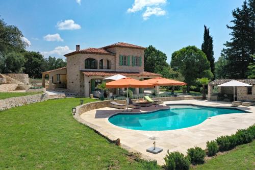 une maison avec une piscine entourée de parasols dans l'établissement 83AVEN - Mas de LAven, à Lorgues